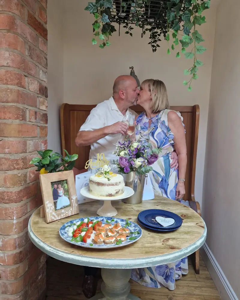 Brad and Linda sharing a kiss and a toast at their 10th anniversary vow renewal